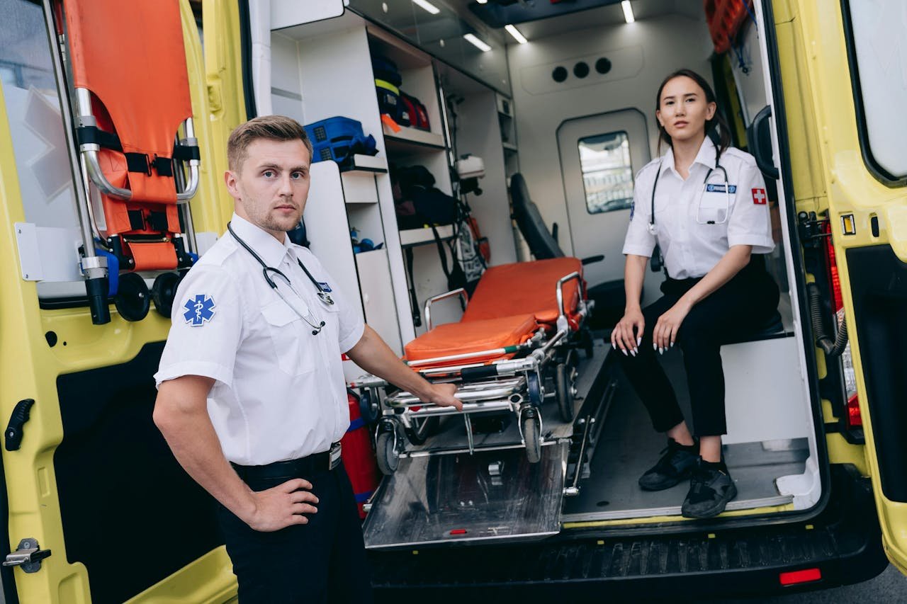 Paramedics prepare for an emergency with medical equipment in an ambulance.