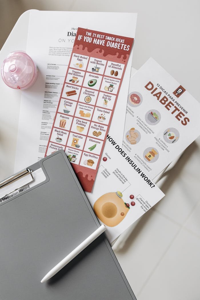 Top view of diabetes educational flyers on a table with a notepad and pen, offering health insights.